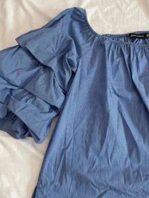 of shoulder topp  - en jätte fin of shoulder blus med volanger💕 skriv om ni har frågor! är en fläck vid bröstkorgen, vet ej om det går bort i tvätten💕