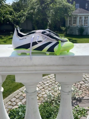 Adidas Predator fotbollsskor svart/vit/grön - Snygga Adidas Predator fotbollsskor i svart och vitt med neongula detaljer och dobbar. Skorna har klassisk snörning och är tillverkade i syntetmaterial för bra grepp och kontroll på planen. Perfekta för dig som vill sticka ut på fotbollsplanen. Säljer pga att de inte passar min foot använt 2 gånger och de är i super bra skick i PRO modell, pris går att förhandla vid snabb affär nu pris 1300kr