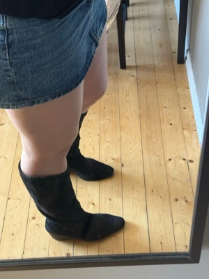 Svarta cowboy boots i mocka - Höga boots. Köpta från Nelly och är i storlek 40. Använts en del men är i fint skick.