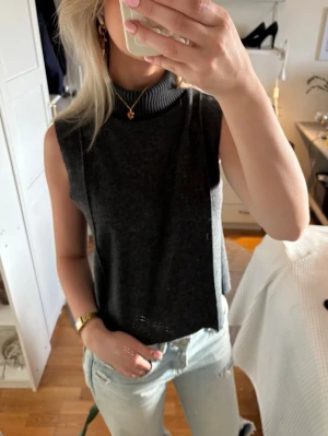Mörkgrå polotopp  - Snygg mörkgrå ärmlös polotopp med ribbad hög krage, endast använd enstaka gånger annars jättebra skick och inga defekter, bara höra av sig vid frågor eller diskutera pris 😇