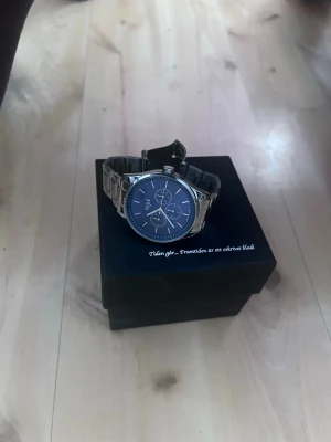 Blå klocka med silverlänk från Axcent - Stilren klocka från Axcent med blå urtavla och silverfärgad länk i metall. Klockan har tre mindre urtavlor och tydliga markeringar. Perfekt accessoar för dig som gillar en klassisk men modern look.