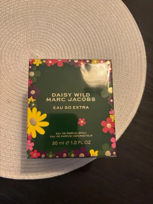 Marc Jacobs Daisy Wild Eau So Extra 30ml - En oöppnad doft i 30ml. Toppnoter: Blå banan, päronnektar, italiensk bergamott och Chocolate Daisy ScentTrek™. Hjärtnoter: Jasmin sambac, Chocolate Viennois Delight och apelsinblomma. Basnoter: Vanilj, amber, sandelträ och vetiver