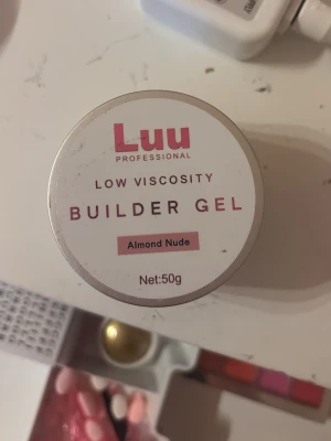 Luu Builder Gel Almond Nude 50g - Builder gel från Luu Nails i färgen Almond Nude. Gelen har låg viskositet och kommer i en rund burk på 50g. Lite mer av en beige ton! Ungefär halva använd, säljer denna eftersom jag tycker det är svårt att arbeta med låg viskositet! Är öppen för prisförslag!!