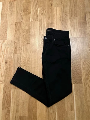 Svart Nudie Jeans - Stilliga svarta Nudie jeans för män till salu. Plagget är nyskick, inga skador/slitage. Storlek Waist 31 / Lenght 30. Hör av dig vid intresse/frågor. PRIS KAN DISKUTERAS!