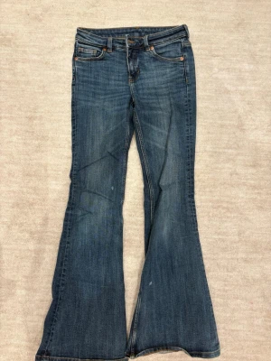 Blå bootcut jeans  - Mörkblå lågmidjade bootcut jeans storlek 26/32. Två små fläckar från målarfärg.