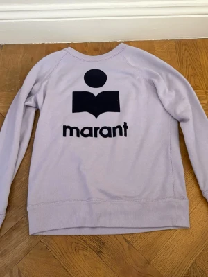 Ljuslila sweatshirt från Isabel Marant - Säljer en ljuslila sweatshirt från Isabel Marant med det ikoniska svarta logotrycket på bröstet. Jättefint skick och perfekt färg! Endast använd ett fåtal gånger av mig. 
