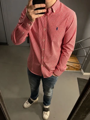 Polo Ralph lauren skjorta - rutig - medium - Klassisk röd och vit rutig skjorta från Ralph Lauren med blå broderad logga på bröstet. Skjortan har lång ärm, knappar framtill och button-down krage. Tillverkad i mjuk bomull och passar perfekt för en stilren look. Se måtten på skjortan på sista 2 bilderna. Sitter som en medium enligt mig. Priset är diskutabelt vid snabb affär. Fråga vid funderingar 🚀☀️
