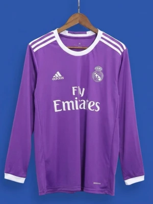 Lila Real Madrid långärmad fotbollströja - Säljer en lila långärmad Real Madrid fotbollströja från Adidas med vitt klubbmärke, Adidas-logga och Fly Emirates-tryck. Tröjan har vita detaljer vid krage och axlar samt är tillverkad i lätt och ventilerande climacool-material.