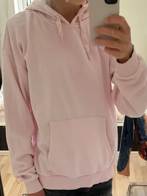 Ljusrosa hoodie med huva - Säljer en ljusrosa hoodie från Gina tricot med huva och dragsnören. Använd några fåtal gånger, först än till kvarn💓