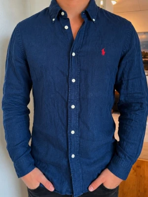Marinblå linneskjorta från Ralph Lauren  - Fint skick! Strl 14-16 år, passar ca 165 cm  Hör av dig vid frågor! 