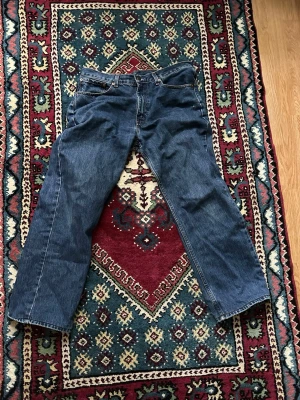 751 Levis Baggy Jeans  - Säljer ett par blå jeans med rak passform och fem fickor. Jeansen har normal midja och klassisk denimlook med synliga sömmar. Perfekta för en avslappnad stil och passar till det mesta. Materialet är kraftig bomullsdenim.