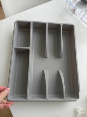 Grå besticklåda i plast - Praktisk grå besticklåda från IKEA i tålig plast med flera fack för enkel organisering av bestick och köksredskap. Passar perfekt i kökslådan för att hålla ordning på knivar, gafflar och skedar. Liten skada finns kolla sista bilden. Den ä 26x30cm