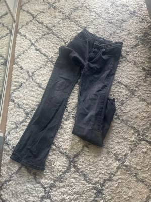 Svarta bootcut jeans från ONLY - Snygga svarta bootcut jeans från ONLY med klassisk femficksdesign och bälteshällor. Jeansen har en något utsvängd passform nedtill och är tillverkade i stretchigt denimtyg för extra komfort. Perfekta för en trendig och avslappnad look.
