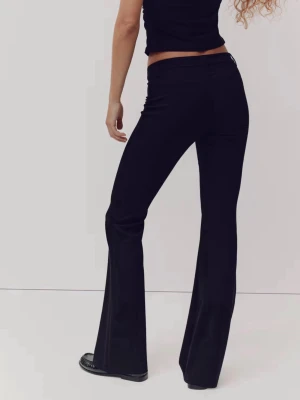 Svarta utsvängda kostymbyxor - Säljer dessa svarta kostymbyxor från H&M med utsvängda ben och hög midja. Byxorna har en minimalistisk look med diskreta bakfickor och är tillverkade i ett mjukt, vävt material som ger en dressad känsla. Perfekta för dig som gillar stilrena och trendiga plagg. storlek 38 och passar 36. Endast testade. 