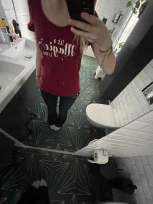 Röd t-shirt med tryck - Snygg röd t-shirt med vitt texttryck på framsidan. T-shirten har rund halsringning och korta ärmar. Perfekt för dig som vill ha en enkel men ändå uttrycksfull stil.