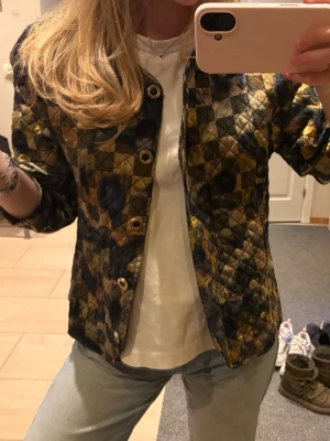 Quiltad cardigan med rutmönster - Snygg quiltad cardiganjacka med rutigt mönster i svart, guld och brunt. Jackan har rund halsringning, guldfärgade knappar och raka ärmar. Vintage från Kurt Kellermann 👌🏽👌🏽🧚🏽🧚🏽🧚🏽