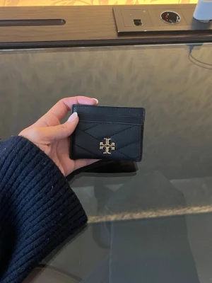 Korthållare från Tory Burch - Svart korthållare i modellen Kiva Chevron från Tory Burch. Använd men fortfarande i ett fint skick!! Hör av dig för frågor 🥰🥰🥰(nu pris 1400)
