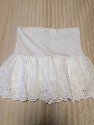 Vit broderad kortkjol från Subdued - Vit kortkjol från Subdued i bomull med broderade blommor och volangkant. Kjolen har bred midjeresår och spetsdetaljer längst ner för en somrig vibe.