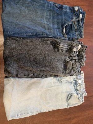 Tre par jeans i olika färger (Frakt i själva priset) - Säljer tre par jeans i olika färger: klassisk blå, svartgrå tvätt och ljust tvättad. Alla har samma storlek och modell. Materialet är denim i bomull. Perfekta för dig som gillar att variera din stil med olika tvättar och färger.