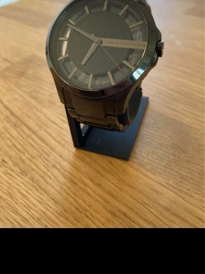 Armani Exchange AX2189 46mm Herrklocka - Säljer en Armani Herrklocka i unik design i gott skick. Finns enstaka märken och en skada i glaset. Fungerar utmärkt, original armband i rostfritt stål, vattentät, mineralglas, osv. Behöver bara nytt batteri.  Nypris: < 3000 SEK Mitt pris: 489 SEK  Skickas alltid snabbt och spårbart (ofta samma dag) eller hämtas i Glumslöv.  Hör av dig vid frågor och se gärna mina andra annonser också!  This Armani Exchange men's watch features a sleek textured black dial with cut-through index ring and a y-link