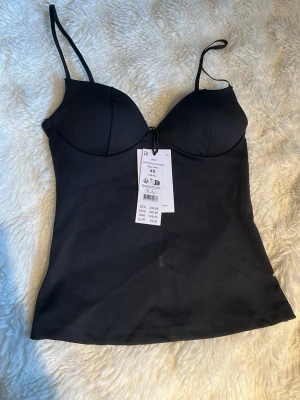 Svart topp - Svart topp från Gina Tricot. Helt ny i storlek xs. Stretchigt material. Perfekt utgångstopp.