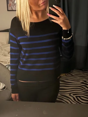 Svart och blårandig stickad tröja från Zara  - Säljer en svart stickad tröja med blå ränder. Tröjan har rund halsringning och långa ärmar. Passar perfekt till jeans eller kjol. Materialet är mjukt och följsamt.💗