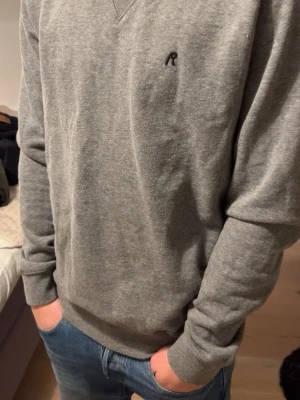 Grå sweatshirt från Replay  - Snygg grå sweatshirt från Replay med broderad logga på bröstet. Tröjan har rund halsringning med dekorativ söm och långa ärmar. Tillverkad i mjukt bomullsmaterial som känns skönt mot huden. Perfekt till jeans eller joggers.