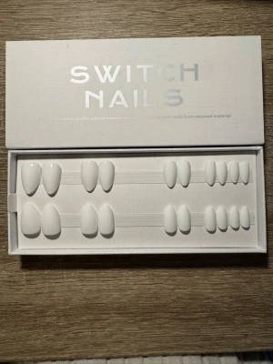 Switch Nails Like A Virgin Almond Short - Press-on naglar från Switch Nails i modellen Like A Virgin. Naglarna har en kort mandelform och är helvita med en glansig finish. Tillverkade av återvunnet material och levereras i en stilren ask. Säljs utan tillbehör.
