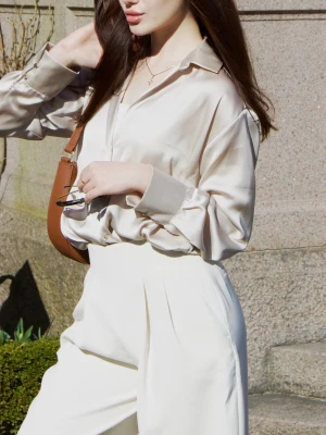 Zara blouse  - Stilren beige satinblus med klassisk krage och knäppning framtill. Blusen har långa ärmar med breda manschetter och en avslappnad passform som ger en lyxig känsla. Perfekt att styla med både jeans och kostymbyxor.