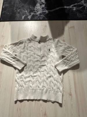 Sweater: Polo Ralph Lauren Cable-Knit Quarter-Zip M 👕 - This is a brand new Polo Ralph Lauren cable-knit quarter-zip sweater in a classic cream color, featuring the iconic embroidered polo player logo on the chest. Made from a comfortable cotton blend, it boasts a textured cable knit design and a functional quarter-zip closure with a branded pull, still retaining its original tags.  ⭐️ Condition : 10/10 (New with tags) 🎲 Size : M 🎨 Color : Cream 📦 Fast and careful shipping