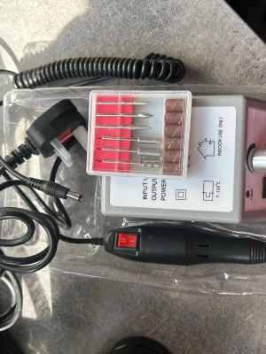 Elektrisk nagelfil med tillbehör - Elektrisk nagelfil i svart och grått med flera sliphuvuden och slipband. Perfekt för att fila, forma och polera naglar. Kommer med strömadapter och olika bits för olika användningsområden. Allt levereras i originalkartong.