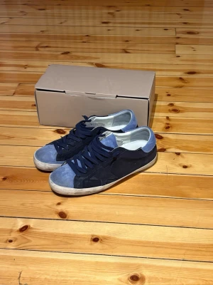 Golden Goose skor  - Säljer dessa Golden Goose Super Star Suede.          Skick: 9/10.                                                                    Storlek: 45 men de är väldigt små i storleken så de passar 43,5-44. Hör av er om ni vill ha mått på sulan mm                                                               Det som ingår i köpet är skorna, dustbag och skolådan 