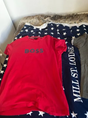 Röd BOSS t-shirt i bomull - Snygg röd t-shirt från BOSS med tryckt logga på bröstet. Klassisk rund hals och korta ärmar. Tillverkad i mjuk bomull och har en normal passform. Perfekt för en avslappnad och trendig stil.