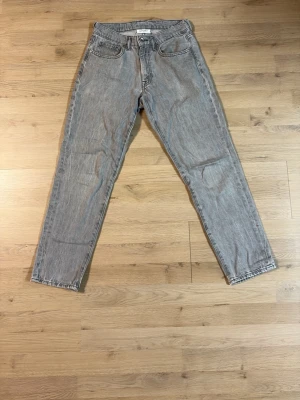 Grå raka jeans från Vailent - Säljer ett par grå jeans från Vailent med rak passform och klassisk femficksdesign. Jeansen har en ljusgrå tvätt och är tillverkade i bomull. Perfekta för en avslappnad och stilren look.