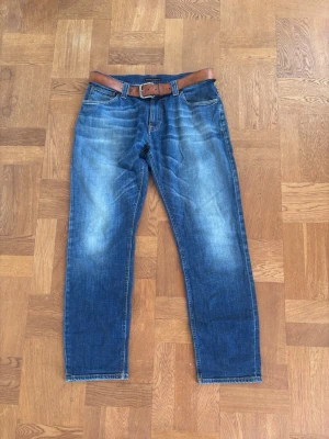 Nudie jeans  - Snygga blå jeans med klassisk tvätt och raka ben. Jeansen har fem fickor. Perfekta för en avslappnad stil och passar till det mesta. Materialet är denim i bomull. Säöjes utan bältet