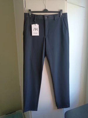 Selected Homme byxor W33 L34 - Ett par stilrena, mörkblå byxor från Selected Homme. Byxorna har en slim passform och är i storlek W33 L34.