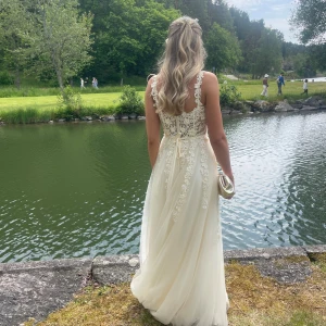 Ljusgul balklänning - En ljusgul lång balklänning med blommig spets och tyll nertill💛Köptes på dressroom i Göteborg för 5500kr (modell: Heaven). Använd en gång och är kemtvättad efter det. Fodral medkommer och även prislapp. Är i storlek 36 men passar även storlek 38. Väskan går att köpa till för 100kr 🌼🫶🏼