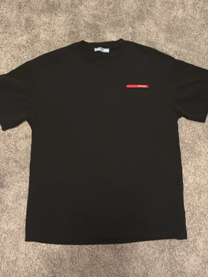 Svart t-shirt prada - Prada t shirt svart helt ny aldrig använd lite stor i storleken men top klass kvalitet pris kan diskuteras vid snabb affär