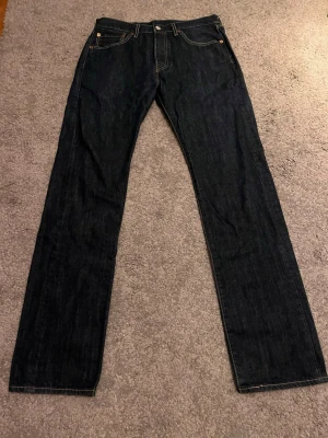 Mörkblå Levi's 501 jeans - Säljer ett par Levi's 501 jeans med mörkblå wash, rak/skinny passform. Inga brister/defekter. Strl W31 L34. Hör av för fler bilder/frågor💯