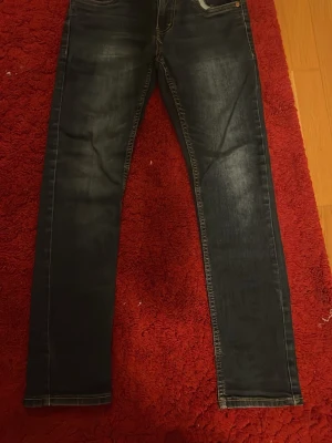 Mörkblå jeans från Levi's - Snygga mörkblå jeans från Levi's med klassisk femficksmodell och slim fit. Jeansen har snygg tvätt framtill och kontrastsömmar. Perfekta till vardagslooken och passar till det mesta. Tillverkade i slitstark denim.
