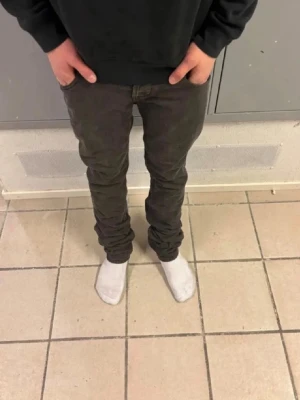 Mörkgrå slim fit jeans - Snygga svarta slim fit jeans med klassisk femficksdesign och låg midja. Jeansen har smal passform och är tillverkade i ett stretchigt denimtyg som ger en bekväm känsla. Perfekta för en trendig och avslappnad look. Modellen är ”Dondup Lucky”. Jeansen är slitna på lapparna på insidan, därav ett billigt pris. Nypris cirka 2200kr. Jeansen är såklart äkta. Midja 37cm, ytterben 103cm.