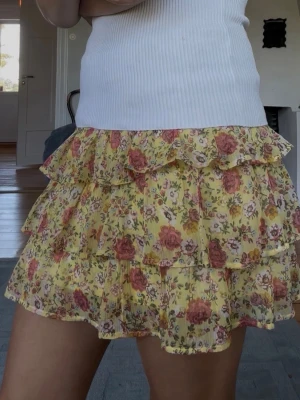 Gul blommig volangkjol - Supersöt kort kjol i gul färg med blommigt mönster och flera volanger. Är en barn kjol men passar ju mig och alla mina vänner som är betydligt äldre än 8-10. Så himla fin och i super bra skick, skriv för frågor❤️