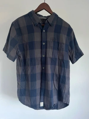 Harley-Davidson kortärmad skjorta - Harley-Davidson kortärmad skjorta Storlek: M Passform: Regular Fit Krage: Button-down Material: Bomull Mått: Bröstvidd 92 cm, längd 62 cm, axel 42 cm Skick: Skjortan är i ett väldigt fint skick utan defekter  Nypris cirka: 900 kr