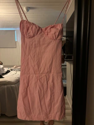 Rosa kort klänning med tunna band - Söt rosa kort klänning från H&M. Slutsåld på hemsidan, använd 1 gång, super fint skick och väldigt söt.
