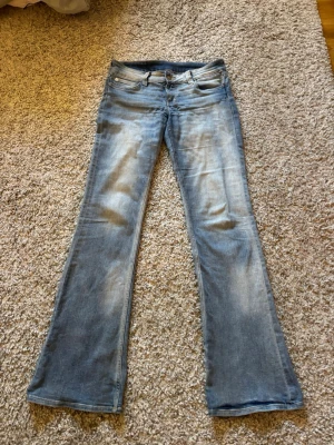Booty bei jeans - Ljusblå urtvättade bootcut/flare lågmidjade jeans från Cheap Monday i storlek 29/34. Stretchmaterial. Små slitningar längst ned bak vilket framgår på bilderna.