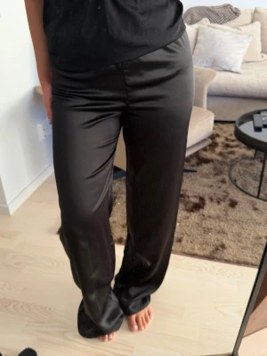 Satin byxor - Helt nya svarta satin byxor från Mango med lappen kvar. Storlek M. Jag är 165 och de är gabska långa men man kan enkelt sy upp dom. 