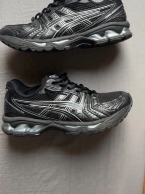 Asics gel kayano 14 helt svart RIKTIGA - Helt bra kondition där Bakk slitna är lite sönder men man märker inget på det men den är bra kondition. Lite smustigt. Prisen kan diskuteras
