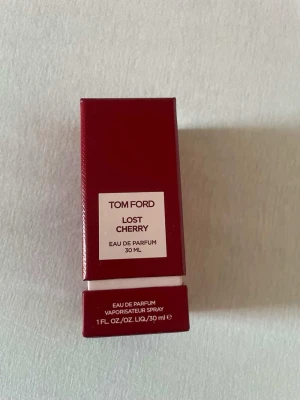 Tom Ford Lost Cherry 30 ml parfym - Tom Ford Lost Cherry Eau de Parfum i en snygg röd glasflaska med matchande röd kartong. Flaskan har en fyrkantig form och ett elegant lock. Doften är känd för sina söta och fruktiga körsbärstoner. Perfekt för dig som gillar lyxiga och unika parfymer.  Den är helt ny har endast sprayat en gång för att lukta på den men annars oanvänd 