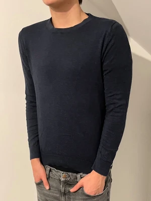 Mörkblå tunn tröja Dressmann - Mörkblå tunn tröja från Dressmann med rund halsringning och långa ärmar. Storleken på tröjan är S och är i mycket bra skick. Modellen i bilden är 188cm lång och väger 74kg 