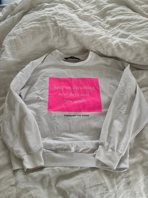 Vit sweatshirt med rosa tryck - Vit sweatshirt från Intersport med ett stort rosa tryck på framsidan.💓 Tröjan har rund halsringning, långa ärmar och ribbade muddar. Passar dig som vill ha en cool och skarp look😍🩷🤍